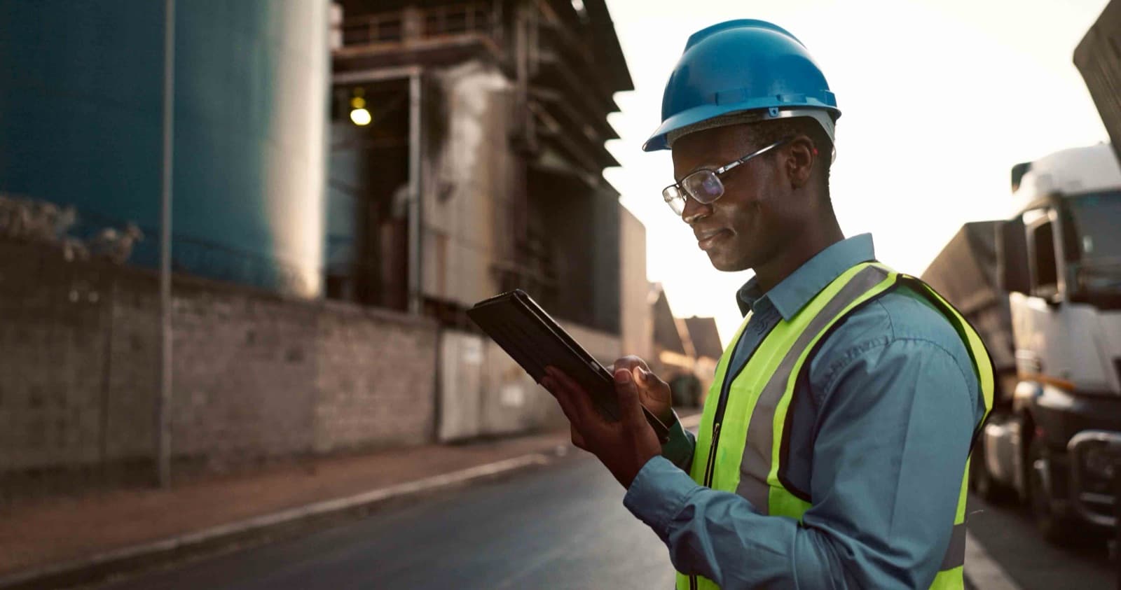 Responsable logistique consultant une tablette sur un site industriel